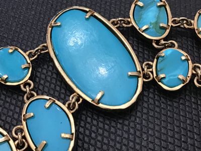 Sale Photo Thumbnail #202: Bold gold-tone link statement bracelet featuring textured, hammered-style bezel settings with bright turquoise-colored cabochons and faceted stones. Features a textured toggle closure. In good pre-owned condition with no  minor wear to the finish.