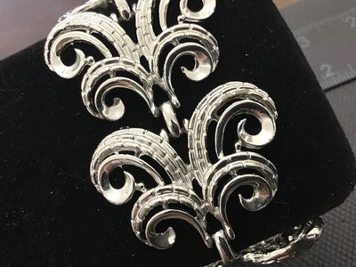 Sale Photo Thumbnail #19: A vintage silver-tone costume jewelry link bracelet featuring ornate scroll/swirl filigree-style links with textured detailing. Measures approximately 7.5 inches in length with a fold-over clasp. Good condition with light vintage wear.