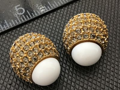 Sale Photo Thumbnail #38: Pair of designer vintage Blair Delmonico clip-on earrings. Features a textured gold-tone setting pave-set with sparkling clear rhinestones, accented with a smooth white cabochon top. Both clips are signed 'Blair Delmonico' on the back plaque. Good pre-own