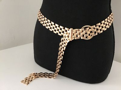 Sale Photo Thumbnail #133: A stylish gold-tone metal mesh link chain belt featuring an interlocking grid pattern and a circular buckle closure. Features a drop tail design. Appears in good pre-owned condition with bright finish and minimal light surface wear.