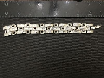 Sale Photo Thumbnail #181: A vintage silver-tone wide link panel bracelet featuring a textured bark-like finish and geometric rectangular cut-out links. Features a fold-over clasp closure. Measures approximately 7.5 inches long. Shows minor vintage wear consistent with age, but ove