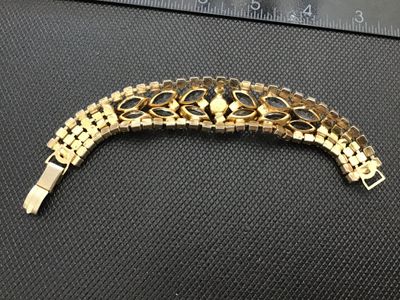 Sale Photo Thumbnail #57: A vintage gold-tone costume jewelry bracelet featuring clear marquise-cut rhinestones flanked by iridescent aurora borealis accent crystals. Features a fold-over clasp closure. Measures approximately 7 inches long. Good vintage condition with light surfac