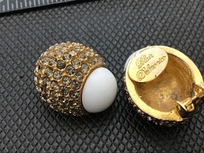 Sale Photo Thumbnail #37: Pair of designer vintage Blair Delmonico clip-on earrings. Features a textured gold-tone setting pave-set with sparkling clear rhinestones, accented with a smooth white cabochon top. Both clips are signed 'Blair Delmonico' on the back plaque. Good pre-own