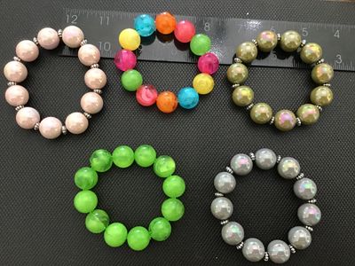 Sale Photo Thumbnail #11: Lot of 5 beaded stretch bracelets featuring oversized round beads in various colors, including pearlescent pink, iridescent olive green, iridescent gray, bright green, and a multi-color marbled style. Most bracelets include small decorative silver-tone sp