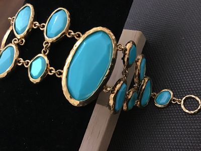 Sale Photo Thumbnail #204: Bold gold-tone link statement bracelet featuring textured, hammered-style bezel settings with bright turquoise-colored cabochons and faceted stones. Features a textured toggle closure. In good pre-owned condition with no  minor wear to the finish.