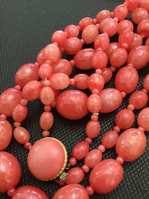 Sale Photo Thumbnail #224: A vintage double-strand beaded necklace featuring salmon pink molded plastic oval and round beads with smaller spacer beads. Includes a gold-tone push-in box clasp with a matching cabochon accent, marked 'HONG KONG' on the reverse. In good vintage conditi