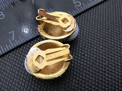 Sale Photo Thumbnail #41: Pair of designer vintage Blair Delmonico clip-on earrings. Features a textured gold-tone setting pave-set with sparkling clear rhinestones, accented with a smooth white cabochon top. Both clips are signed 'Blair Delmonico' on the back plaque. Good pre-own