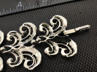 Sale Photo Thumbnail #22: A vintage silver-tone costume jewelry link bracelet featuring ornate scroll/swirl filigree-style links with textured detailing. Measures approximately 7.5 inches in length with a fold-over clasp. Good condition with light vintage wear.