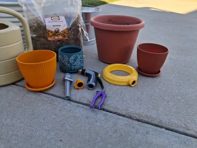 Sale Photo Thumbnail #105: ASSORTED GARDENING SUPPLIES INCLUDING A BAG OF ADAMAN DRIED BSF LARVAE, PLASTIC AND CERAMIC PLANTERS, GALVANIZED BUCKET, WATERING CAN, HOSE NOZZLES, SPRINKLER RING, PRUNERS AND MORE. ITEMS SHOW LIGHT SIGNS OF USE.