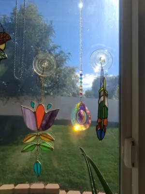 Sale Photo Thumbnail #380: SET OF STAINED GLASS SUN CATCHERS AND CRYSTAL PRISM HANGINGS INCLUDING FLOWER, FEATHER DESIGN, AND MORE. GOOD CONDITION.