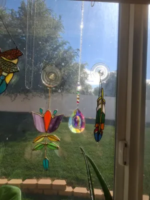 Sale Photo Thumbnail #381: SET OF STAINED GLASS SUN CATCHERS AND CRYSTAL PRISM HANGINGS INCLUDING FLOWER, FEATHER DESIGN, AND MORE. GOOD CONDITION.