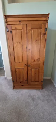 Sale Photo Thumbnail #35: Rustic pine armoire or wardrobe featuring double paneled doors, crown molding detail, and wrought iron ring pulls.