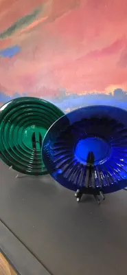 Sale Photo Thumbnail #39: Pair of mid-century art glass display plates in forest green and cobalt blue, shown on display stands.