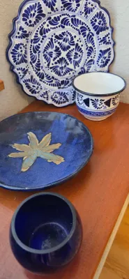 Sale Photo Thumbnail #21: Collection of blue ceramic decor, including a hand-painted Mexican Talavera style platter, matching small bowl, artisanal floral dish, and a cobalt glass vessel.