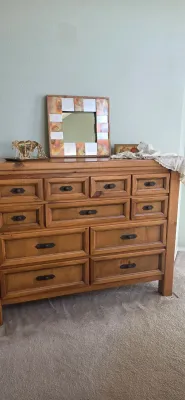 Sale Photo Thumbnail #15: Rustic pine multi-drawer dresser featuring dark metal hardware, topped with a decorative mosaic-framed wall mirror and small decor accents.