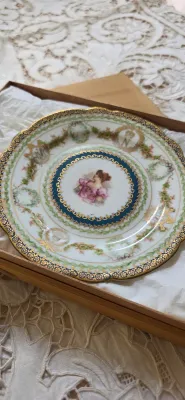 Sale Photo Thumbnail #23: Antique porcelain cabinet plate featuring a central hand-painted portrait of a woman surrounded by intricate gold gilding, cobalt blue borders, and floral garland motifs.