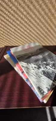 Sale Photo Thumbnail #33: Stack of regional paperback books including "Exploring the Jemez Country" by Roland A. Pettitt, displayed on a wooden surface.