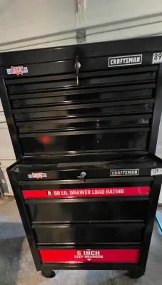 Sale Photo Thumbnail #48: Craftsman two-piece black steel rolling tool chest and cabinet combo featuring multiple drawers with lock and key.