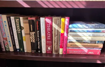 Sale Photo Thumbnail #31: Collection of assorted vintage hardcover books neatly arranged upright and stacked on a dark wooden shelf.