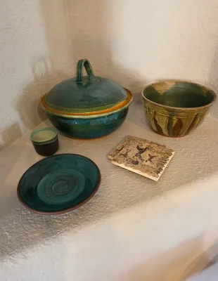 Sale Photo Thumbnail #26: Collection of artisan studio pottery items including a turquoise glazed covered casserole dish, open bowls, a small cup, and a set of cave art themed coasters.