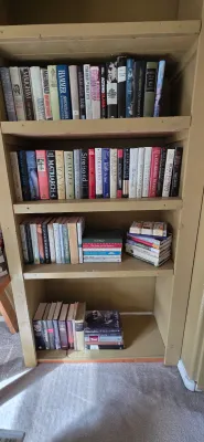 Sale Photo Thumbnail #28: Tall painted wooden bookcase filled with an extensive collection of hardcover and paperback books, featuring biographies, history, and fiction.