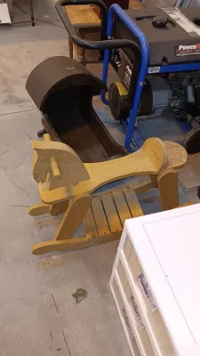 Sale Photo Thumbnail #12: Vintage handmade wooden rocking horse alongside a dark wood miniature cradle and a portable PowerBoss generator.