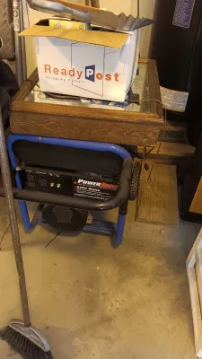 Sale Photo Thumbnail #62: PowerBack 5250-watt portable generator with a blue frame, topped with a wood-framed glass shadow box and a cardboard box.