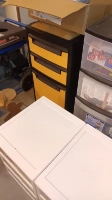 Sale Photo Thumbnail #13: Black and yellow three-drawer tool cabinet positioned near plastic storage drawers and a portable generator.