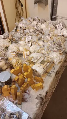 Sale Photo Thumbnail #38: Large collection of bagged decorative sea shells and craft supplies alongside wooden nativity figures arranged on a table.
