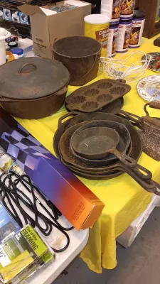 Sale Photo Thumbnail #26: Collection of vintage cast iron cookware including Dutch ovens, skillets, and a muffin pan displaying surface rust.