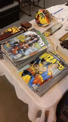 Sale Photo Thumbnail #51: Large collection of vintage Wizard comic magazines displayed in stacks on a table alongside decorative items.