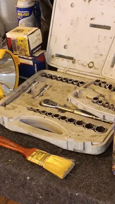 Sale Photo Thumbnail #63: Mechanic's socket and ratchet set in a fitted blow-molded plastic case, displayed alongside a paintbrush, spotlight lantern, and auto care products.