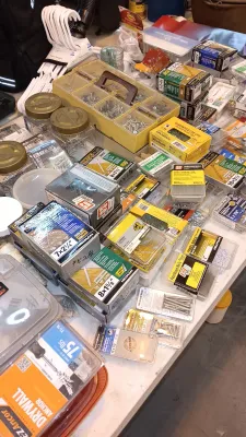 Sale Photo Thumbnail #29: Large assortment of household hardware including boxed deck screws, drywall anchors, panel nails, and a yellow plastic organizer tray filled with loose fasteners.