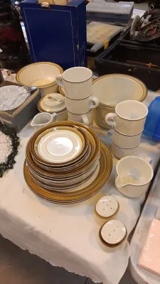 Sale Photo Thumbnail #28: Vintage ceramic dinnerware set with brown band rims, including stacked plates, mugs, bowls, creamer, and salt and pepper shakers.