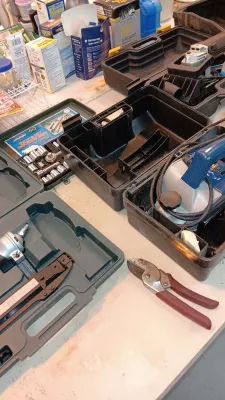 Sale Photo Thumbnail #18: Selection of power and hand tools, including an air nailer kit, a socket set, wire cutters, and various power tools in hard plastic cases.