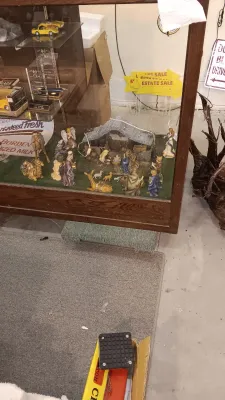 Sale Photo Thumbnail #55: Vintage glass and wood display case filled with collectible items, including a nativity scene set and die-cast model cars.