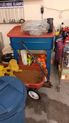 Sale Photo Thumbnail #9: Vintage red Radio Flyer toy wagon showing rust, positioned in front of a blue and red portable parts washer basin.