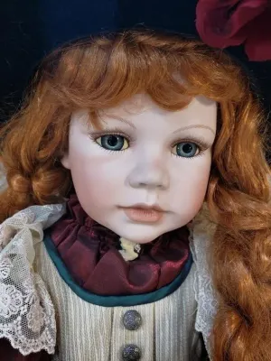 Vintage collector porcelain doll featuring auburn curls, realistic glass eyes, and elaborate lace-trimmed Victorian-style attire.
