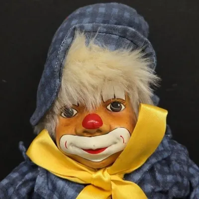 Vintage collectible hobo clown doll featuring a hand-painted ceramic face, faux fur hair, a blue plaid fabric hat, and a yellow satin bow...