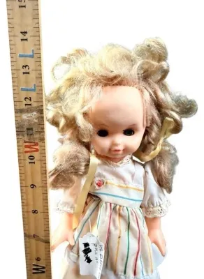 Vintage 13-inch Madame Alexander 'Sleepy Eye' doll with blonde curly hair and striped dress.