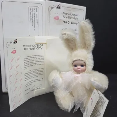 Marie Osmond Fine Porcelain "Bit O' Bunny" collectible doll, featuring a fuzzy cream rabbit suit, original box, and...