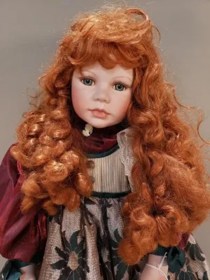Collectible porcelain doll featuring long curly auburn hair, blue-green eyes, and an ornate vintage-style dress.