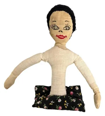 Vintage handmade cloth pincushion doll with hand-embroidered facial features and black yarn hair.