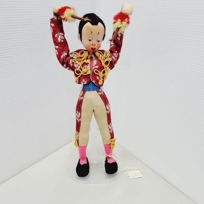 Vintage Spanish matador souvenir doll dressed in a detailed red embroidered suit with gold trim and holding banderillas.