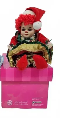 Marie Osmond Fine Collectibles porcelain clown doll dressed in a festive Christmas outfit, seated on its original pink presentation box.