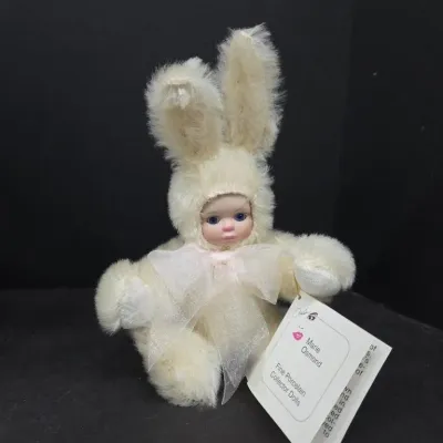 Marie Osmond Fine Porcelain Collector Doll dressed in a plush cream rabbit suit with original hangtag attached.