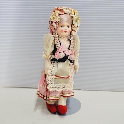Vintage Lenci-style felt souvenir doll with braided hair, floral bonnet, and traditional European folk attire.