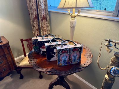 Collection of vintage Enid Collins embellished wooden box purses arranged on a carved piecrust tilt-top table.