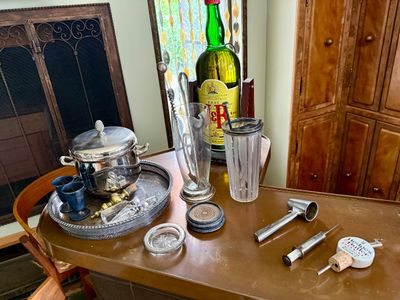 Vintage barware collection featuring a silver-plated ice bucket on a serving tray, crystal and glass cocktail shakers, coasters, bar...