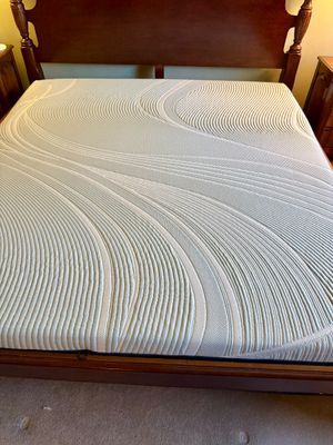 King-size memory foam mattress with a textured wave pattern cover, set in a traditional dark wood bed frame.